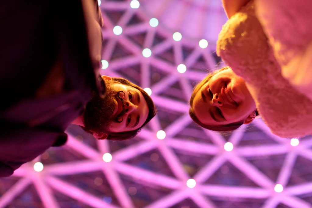 A wedding couple photographed from a low angle with beaufitul violet light at night